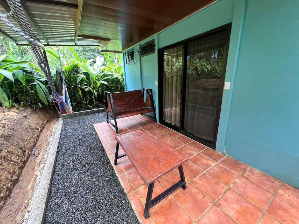 Terraza de la habitación con banca, mesa y jardín